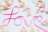 Lettering reading 'Love' and scattered rose petals