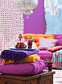 Orientalischer Farbklang - Decken, Kissen und Tablett mit gläserner Teekanne auf einer Holztruhe