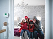 Family wearing snow gear in bedroom