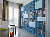 Modernes Bücherregal mit hellblauer Beschichtung und schlichter Arbeitstisch