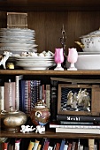 Antique shelf with books, decorative objects and crockery