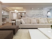 Modern sofa in an open living room with marble walls
