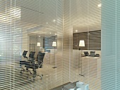 Glaswand mit geöffneter Jalousie und Blick ins moderne Büro