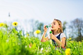 Girl blowing bubbles in field
