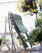 Assorted folding chairs and a small tree with yellow flowers in a pot