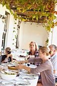 Family eating at table outdoors