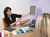 Designer showing carpet samples to client.