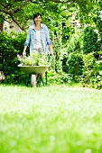 Woman with wheelbarrow in garden