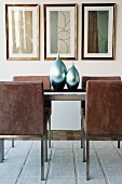 Modern dining table with velvet-covered chairs and gleaming metallic vases