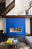 A deep blue fireplace and zebra rug are the attention getters in this modern living room