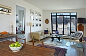 Spannender Stilmix im Wohnzimmer mit zeitgenössischen Designermöbeln und antikem Esstisch