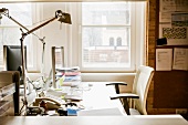 Office desk with lamp, computer, telephone and office supplies