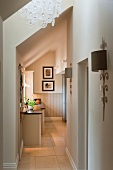 Sunlit hallway with view of kitchen unit in open-plan attic in elegant country-house style