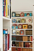 Open shelves with a collection of English Royal Family memorabilia and antique books