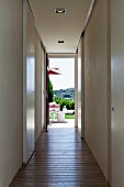 View along hallway to sunny garden terrace with view of landscape