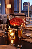 Festlich gedeckter Tisch mit Rosenstrauss in stimmungsvollem Licht