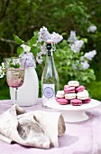 Garden table with lilac linen tablecloth and pink and white macaroons on white cake stand