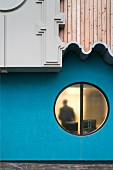 Post modern house facade with a round window and overhanging, ornamental wall elements (BBC Cardiff)
