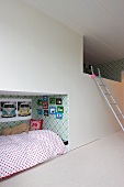 Ladder leading to one of two bunks built into wall of spacious children's bedroom
