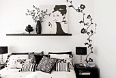 Double bed, feminine black and white wall decoration and photograph of Audrey Hepburn