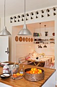 Marmalade ingredients on a solid-oak work surface in a kitchen with pendant lights by Ikea and a wood panelled alcove with benches and dining table