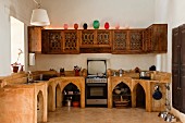 Indian kitchen - masonry kitchen counter with pointed-arch openings in base units and carved wall units