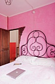Antikes, kunstvolles Metallbett in pinkfarbenem Schlafzimmer