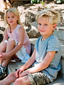 Brother and sister sitting on wooden steps, portrait