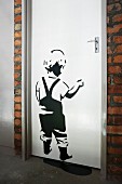 Stencilled picture of child on white door