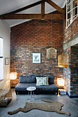 Modern lounge area with hare-shaped rug and brick wall in open-plan, rustic interior