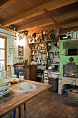 Rustic kitchen with fireplace, wood-fired oven & shelves of kitchen utensils