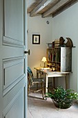 Schlichtes Arbeitszimmer mit Holzbalkendecke und selbst gestaltetem, einfachen Sekretär im Vintage Stil; am Boden Terrakottafliesen