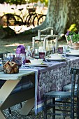 Wooden table set in shades of purple in garden
