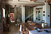 Rustikale, provenzalische Küche in restauriertem Landhaus; durch Glaswand abgetrennte Steintreppe im Hintergrund