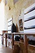 Rustikales Sideboard mit Küchengeschirr und Panoramabildstrecken vor historischem Sandsteingemäuer (Château Maignaut)