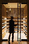Person entering a modern wine cellar