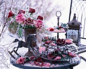 Frozen roses and petals on a metal cake stand and in a vase with a mini rocking horse