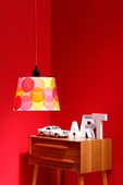 White lampshade covered in circles of colourful tissue paper
