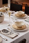 Festively set table with champagne flutes & cream crockery