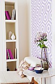 Room corner in violet, purple and white with high bookshelf and patterned wall wallpaper