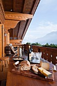 Simple lunch on wooden table on chalet balcony with view of mountain landscape