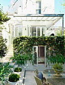 Teilweise mit Glas überdachter, bepflanzter Innenhof mit Terrassen auf verschiedenen Ebenen