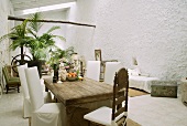 Rustic wooden table and chairs with white covers in Mediterranean loggia