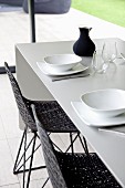 Elegant dining set with grey table and black shell chairs with woven seats