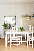 White dining table, chairs and pendant lamps