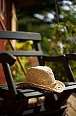 Straw hat on wooden garden chair