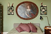 Traditionelles Frauenportrait und Wandgestelle mit Erinnerungsstücken über französischem Bett