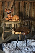 Bambi-Figur auf einem Holzhocker in einer Hütte