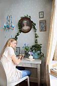 Young woman seated at small console table