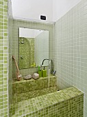 Sink integrated in niche with green mosaic tiles